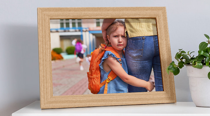 A framed photo of a child who doesn't want to leave their mother