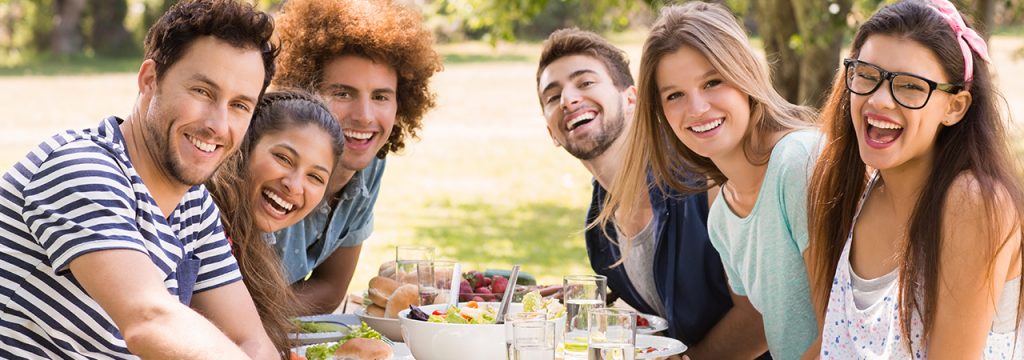 A group of friends celebrate a summer birthday outdoors