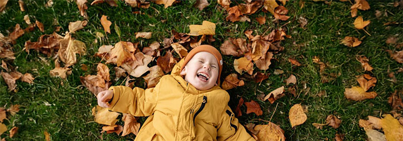 Kid laughing and enjoying autumn.