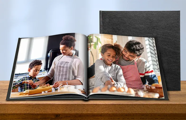 Custom made photo book open on table with photo collage of family photos