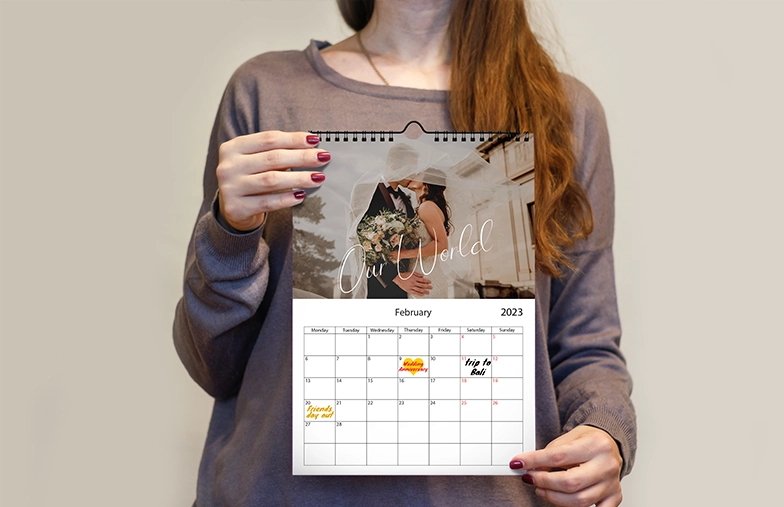 Woman writing on A4 customised wall calendar by printerpix with christmas theme photo