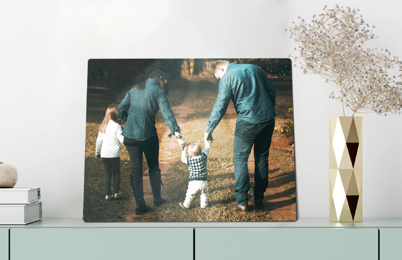 Metal Photo Print by Printerpix|Aluminium photo print of a moutain and a lake being held by woman made by Printerpix|Metal photo print of mom and daughter on bookshelf|A metal print on a wall with a landscape shot; a small metal print of two dogs|A metal print of a bridge with a city skyline in the background|Three metal prints of different sizes showing different landscapes||||| - alternate view