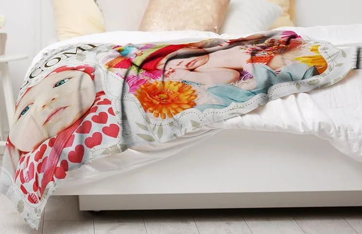 Custom plush fleece photo blanket on a bed with newborn baby photos on by Printerpix
