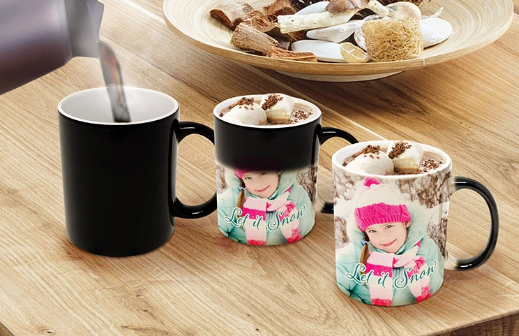 Magic Mug|Three mugs, being filled with hot water to reveal a young girl.|Young boy holding custom designed magic mug with photo of himself on|Magic mug with picture of cat on having tea poured into it on desk|Couple holding two heat changing magic mugs with custom text by Printerpix|Three mugs: one empty (blank), one half full (half an image) and one full (full image)|Grandad and grand daughter holding hands with personalised mug with photo of grand daughter||||