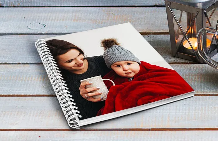 A spiral book on a table with a baby on the cover