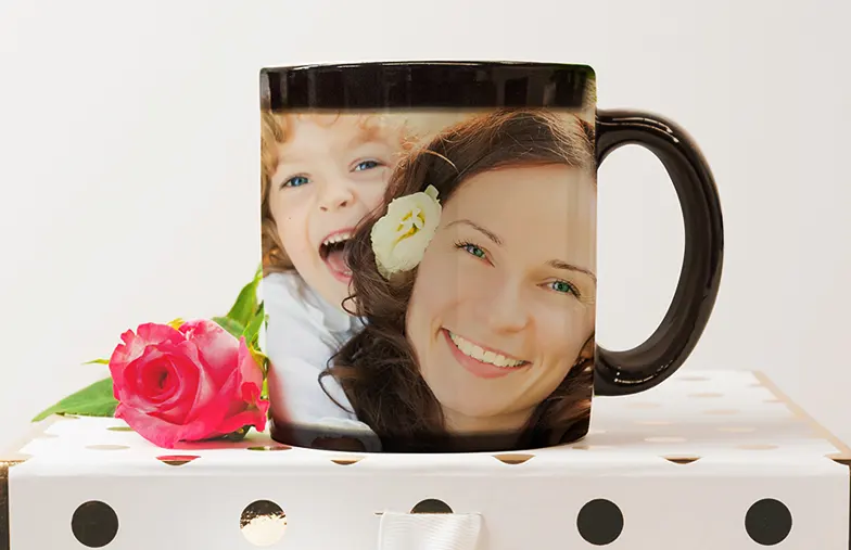 Young boy holding custom designed magic mug with photo of himself on