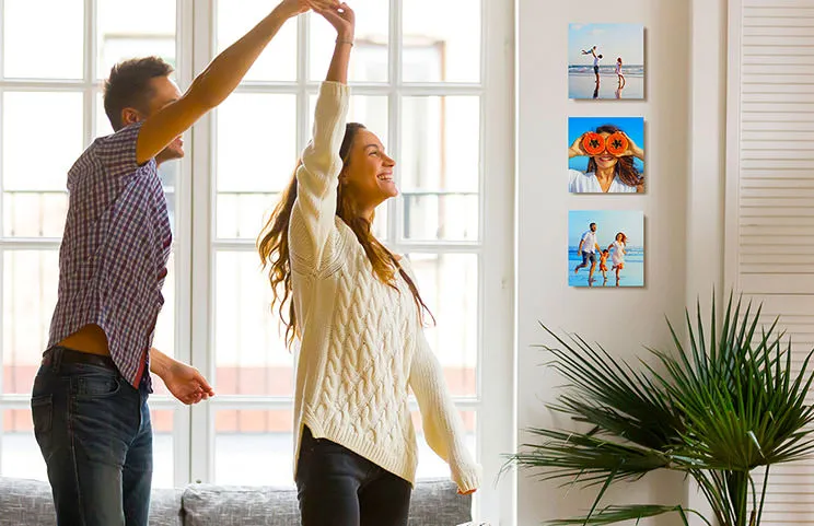 Romantic couple dancing in lounge in front of three custom photo tile prints