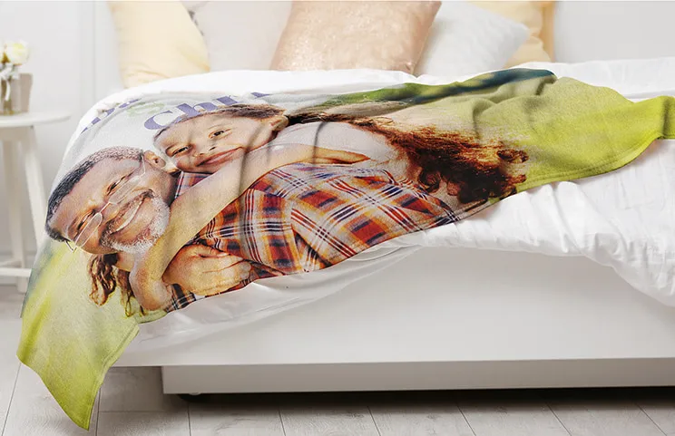 Custom fleece blanket on a bed with family photo