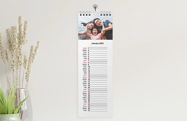 Kitchen calendar hung up on kitchen wall with family holiday photos on