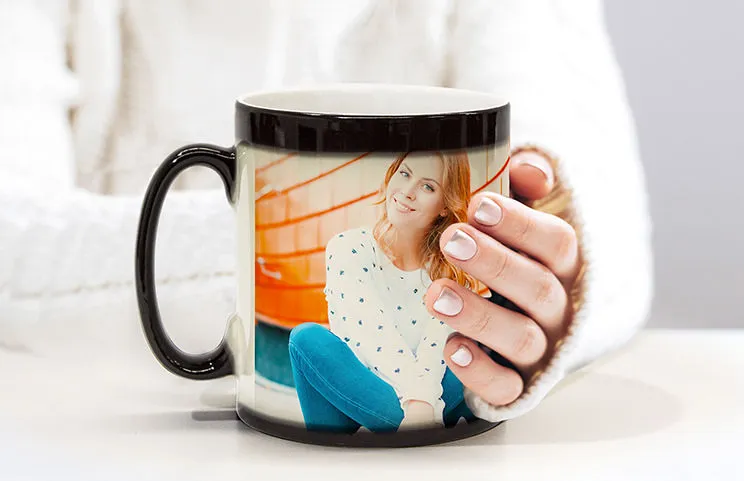 Couple holding two heat changing magic mugs with custom text by Printerpix