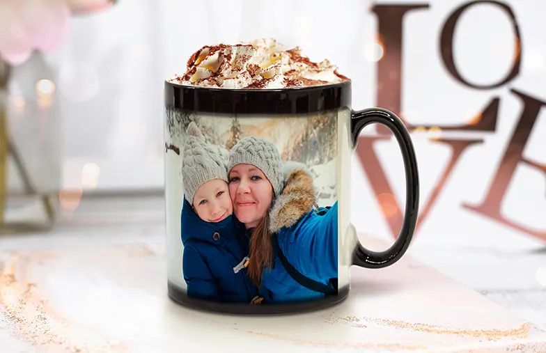 Couple holding two heat changing magic mugs with custom text by Printerpix