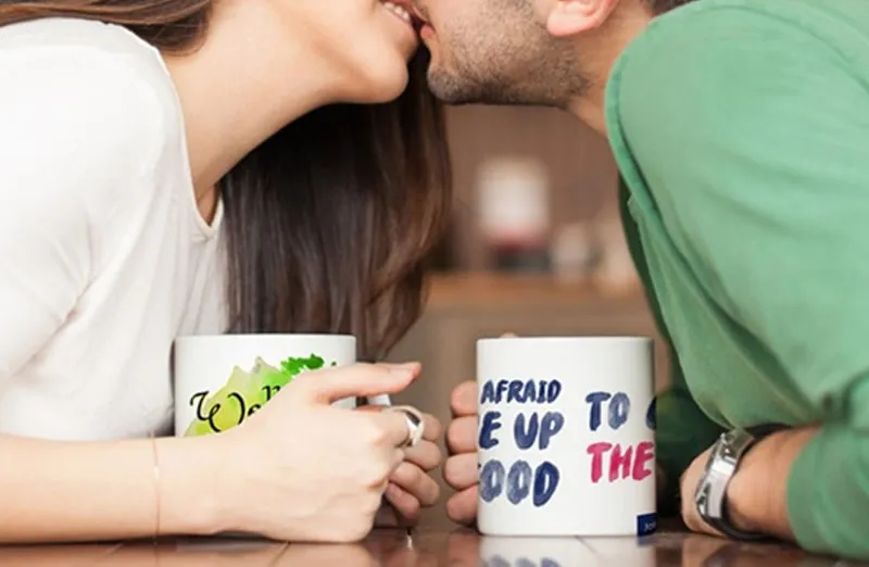 Kissing couple with personalized mugs with text on