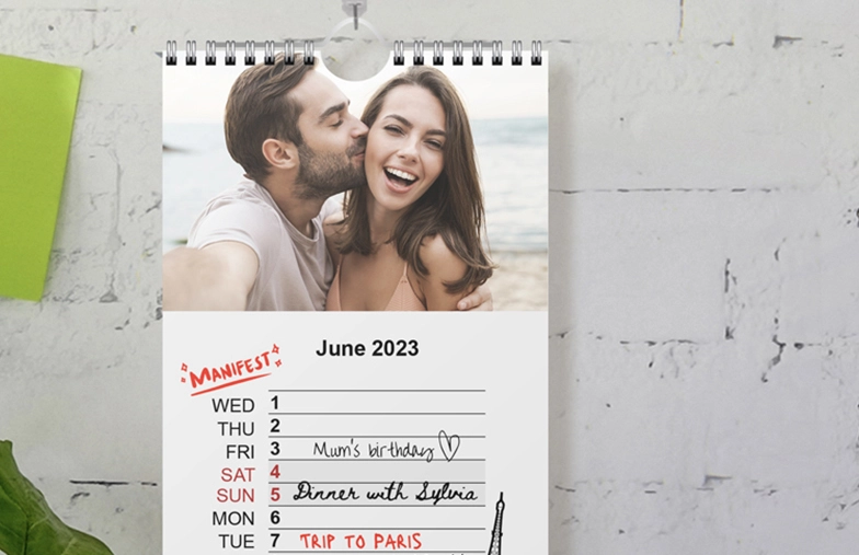 Woman looking at customised calendar with photo of dog taken on mobile